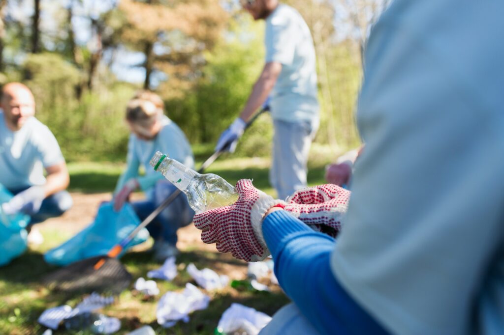 volunteer with trash bag and bottle cleaning area